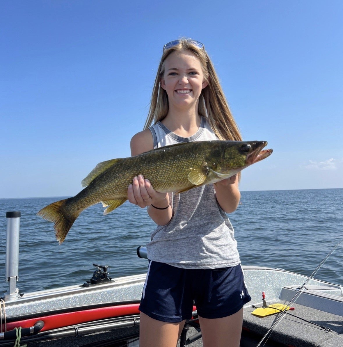 Karys holding a fish on a boat